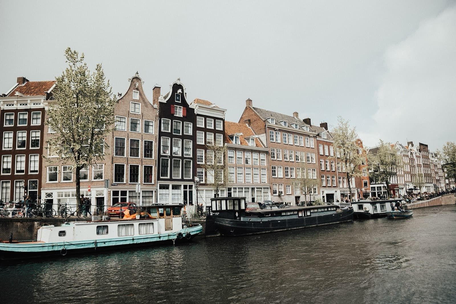 A row of canal houses and houseboats along an Amsterdam canal